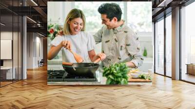 Happy couple cooking in the kitchen Wall mural