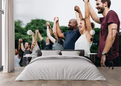 Happy diverse people holding hands in the park Wall mural