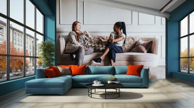 Happy friends enjoying a conversation together on the couch Wall mural