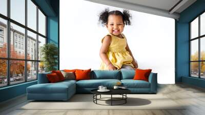 happy little girl in a yellow dress sitting Wall mural