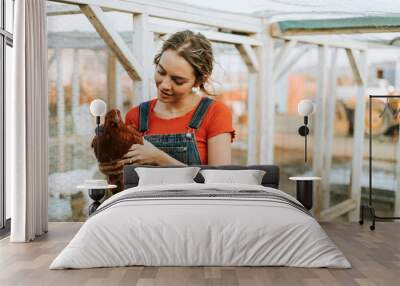 Happy young woman with a brown hen Wall mural