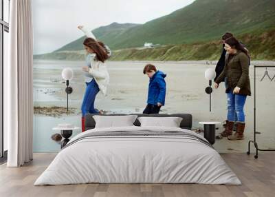 Kids walking on stones at the beach Wall mural