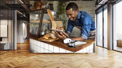 Man using devices for online business order at bakehouse Wall mural