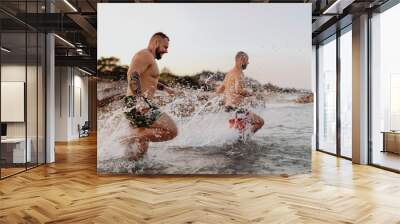 Men running into the water Wall mural