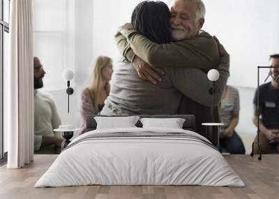 Senior man hugging woman in support group Wall mural