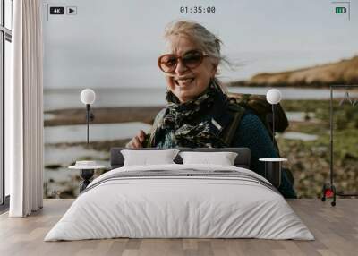 Senior tourist woman walking at the beach Wall mural