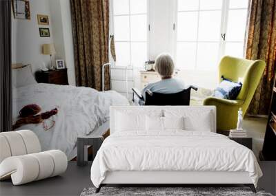 Senior woman sitting on the wheelchair alone Wall mural