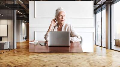 Senior woman working on a laptop Wall mural