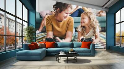 Sisters lying on the floor playing a video game Wall mural