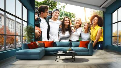 Smiling happy young adult friends arms around shoulder outdoors friendship and connection concept Wall mural