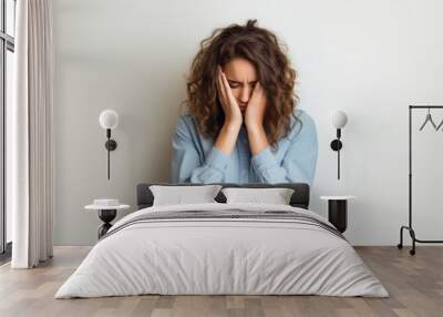 Stressed woman with curly hair Wall mural