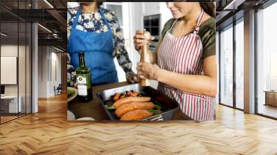 Woman adding spices and herb to raw salmon Wall mural