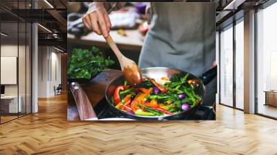 Woman cooking stir fried vegetables Wall mural