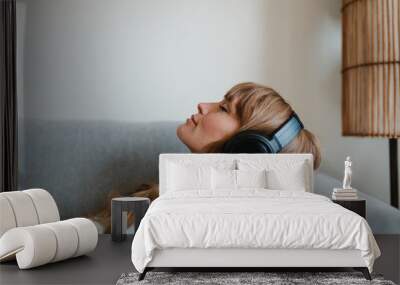 Woman listening to music at home during coronavirus pandemic Wall mural