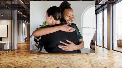 Women hugging each other Wall mural