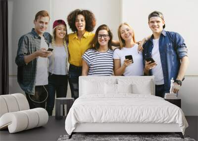 Young adult friends using smartphones together outdoors youth culture concept Wall mural