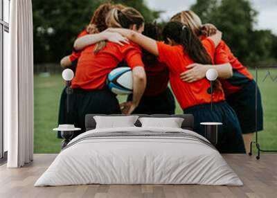 Young female rugby players huddling Wall mural