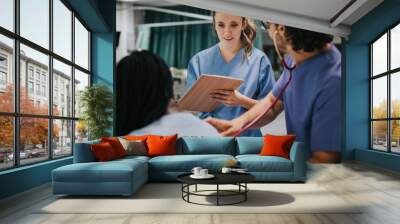 Young male physician examining a patient Wall mural