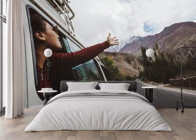 Young woman enjoying traveling by car across mountain landscape Wall mural