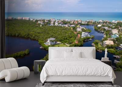 Aerial Drone Perspective of Real Estate in Bonita Springs, Florida with the Bay and a Preserve in the Foreground and the Gulf of Mexico in the Background Featuring a Blue Sky and Blue Water Wall mural