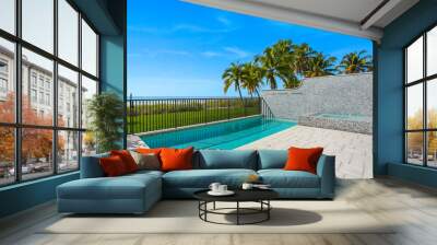 Swimming pool with a beach view and trees in the background Wall mural