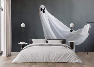 a ghost in a white fabric fluttering in the wind on a gray background in the studio halloween minimal concept Wall mural