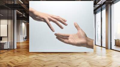 Two male hands reaching towards each other on isolated white background Wall mural