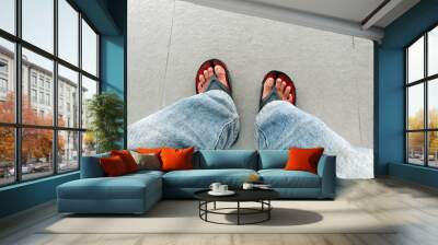 Man feet top view wearing jeans and sandals Wall mural