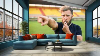 A handsome football referee with a beard plays the whistle Wall mural