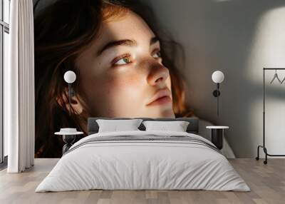 close-up of a face, A woman sitting on a bed looking at the incoming sunlight, longitudinal lighting spotlight, white background Wall mural