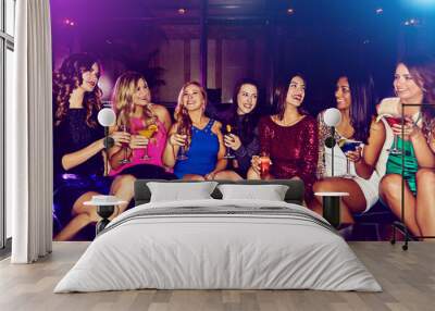 Women, group and friends in nightclub with drink, glass or cocktails for bonding, event or reunion. Smile, relax and happy people in dark disco party couch for fashion, alcohol or social celebration Wall mural