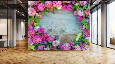 Clover flower pink round frame on knotted wooden background. Medicinal herb clover flowers on circle shape on rotten cracked wood table or floor. Old weathered texture wall & clover plant border Wall mural