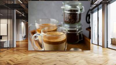 Iced Dalgona coffee drink on wooden tray background. Instant coffee or espresso powder whipped with sugar and hot water. Coffee with milk latte, cappuccino. Two glass cups with double walls. Breakfast Wall mural