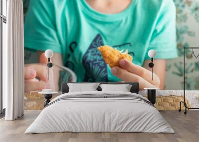 A hungry preteen boy eating chicken nuggets in a restaurant Wall mural