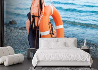 Lifebuoy ring and a life jacket near on a seaside in summer, lifeguard rescue equipment Wall mural