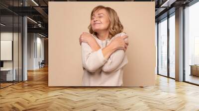 Senior caucasian woman hugging oneself happy and positive, smiling confident Wall mural