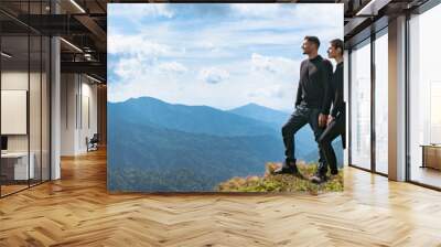 The happy couple standing on the mountain with a picturesque cloudscape Wall mural