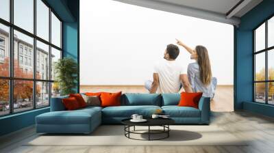 The sitting couple look the empty wall and gesture Wall mural