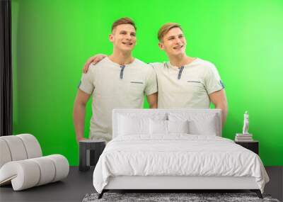 The two happy twin brother stand on the green background Wall mural