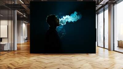 The young man smoke a cigarette against the background of the bright light Wall mural