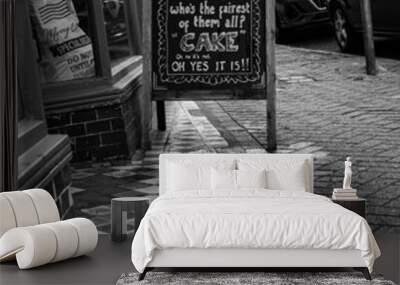 Chalkboard pavement sign in front of a coffee, Eastbourne, England, grayscale image Wall mural