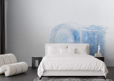 Bottle flake,PET bottle flake,Plastic bottle crushed,Small pieces of cut blue plastic bottles in beaker glass&Bottom of translucent bottle .Chemical concept Wall mural