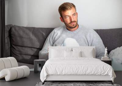 A man sitting on a sofa and reading a book Wall mural