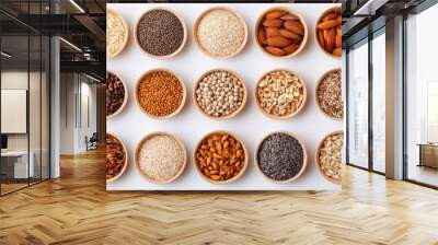 A diverse collection of grains and seeds displayed in wooden bowls showcases their varied textures and colors against a white backdrop Wall mural