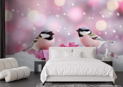 Two birds sit on pink gift boxes surrounded by snow, celebrating the winter season with a joyful atmosphere Wall mural