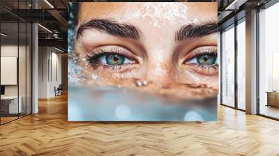 Water droplets glisten on a woman's face as she enjoys a refreshing moment in a tranquil pool on a sunny day Wall mural