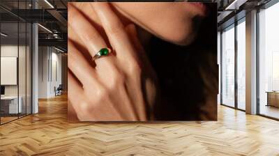 Beautiful woman closeup profile portrait with natural manicure wearing a ring with green gem Wall mural