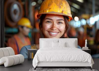 A woman wearing a yellow hard hat and a gray shirt is smiling. She is posing for a photo Wall mural