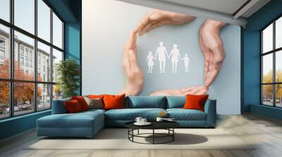 Family care concept. Hands with paper silhouette on table. Wall mural