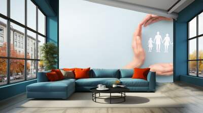 Family care concept. Hands with paper silhouette on table. Wall mural